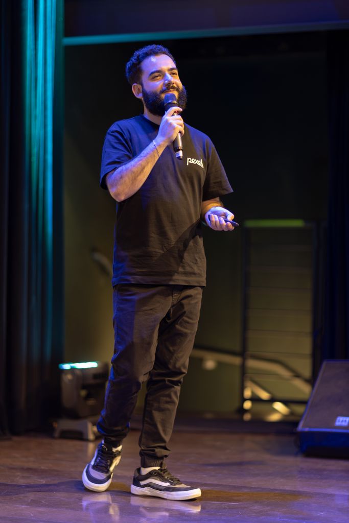 A man speaks confidently on stage, highlighting a professional presentation.